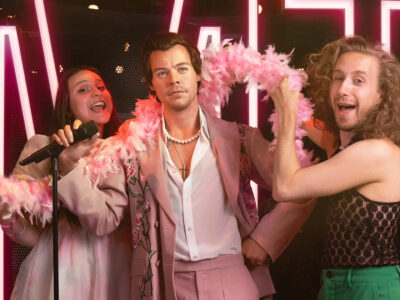 Visitors posing with a wax figure of a male celebrity at Madame Tussauds Amsterdam