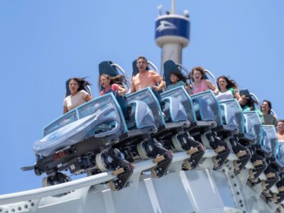 Thrilled riders on the Mako hypercoaster at SeaWorld Orlando under a clear blue sky